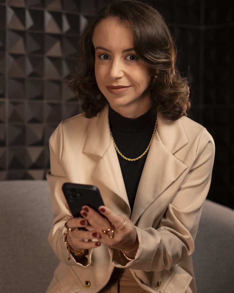 Letícia Tacão segurando o celular com o Bolso Leve
